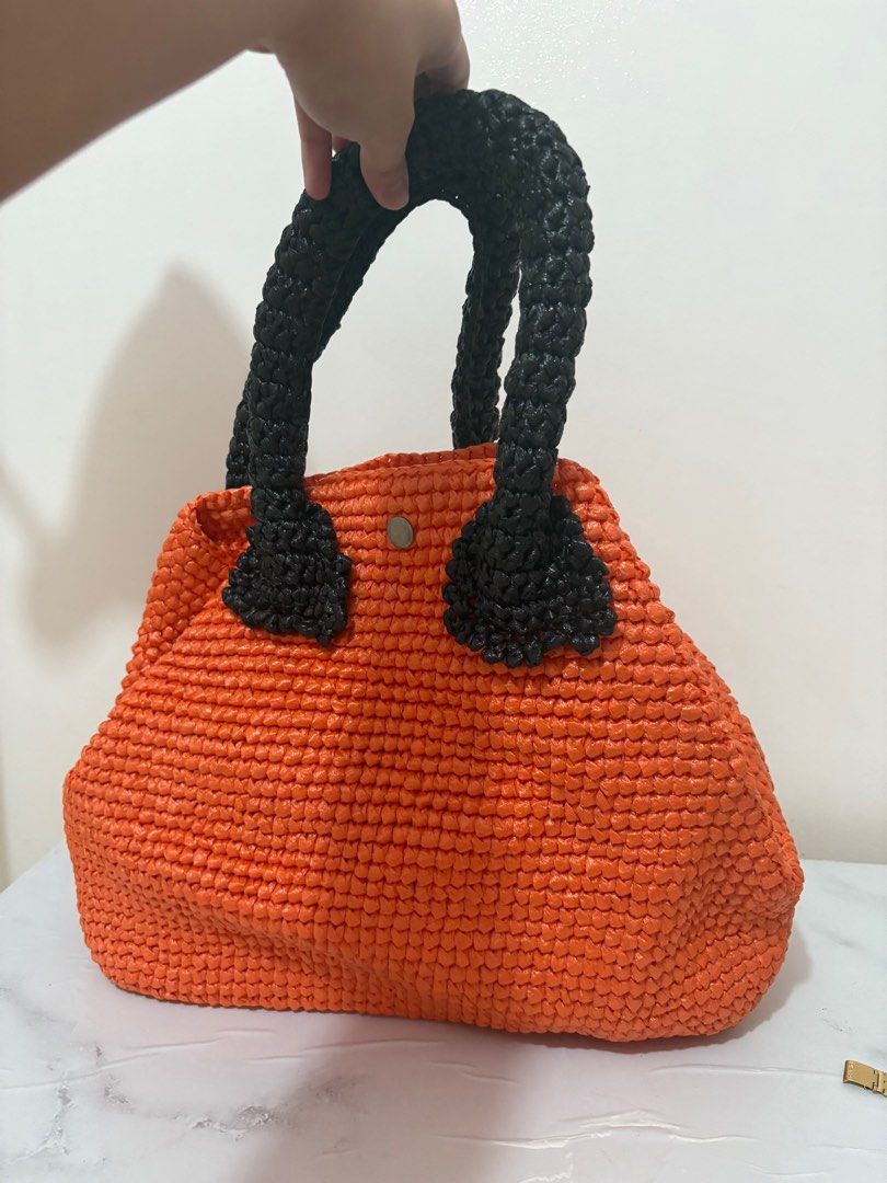 Orange Woven Handbag with Black Handles (Category: Luxury Bags & Wallets) located in Taguig. Submitted by mnom05 (Listing ID 1397940150, Image 2). Description: - Vibrant orange straw woven body - Contrasting black handles - Secure button closure - Spacious interior - Unique woven texture - Comfortable and sturdy handles - Ideal for daily essentials.