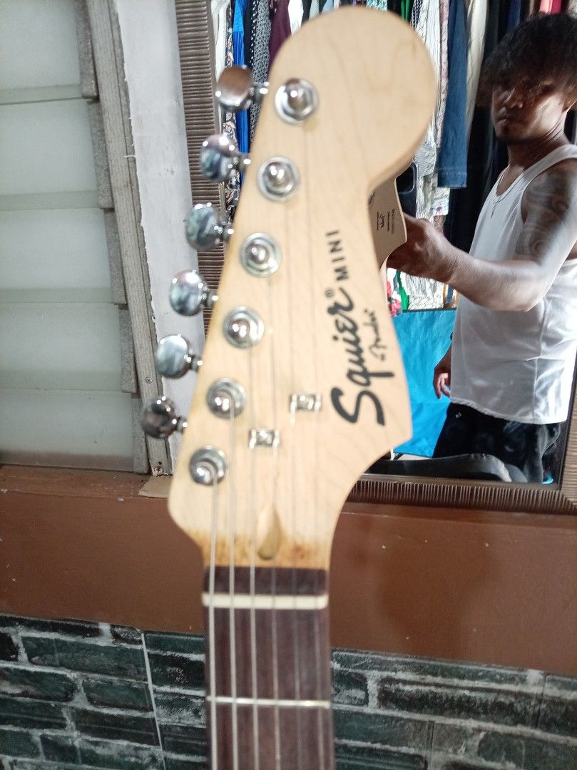 Squier Mini Fender Electric Guitar (Category: Musical Instruments) located in Agdangan. Submitted by hairulmusicalcolection (Listing ID 1397835491, Image 3). Description: - Squier Mini Fender electric guitar - Color: Black - Features: - Maple neck - Black body - Six strings - Tremolo bridge - Includes two control knobs - Headstock with Squier Mini Fender logo - Made in Indonesia.