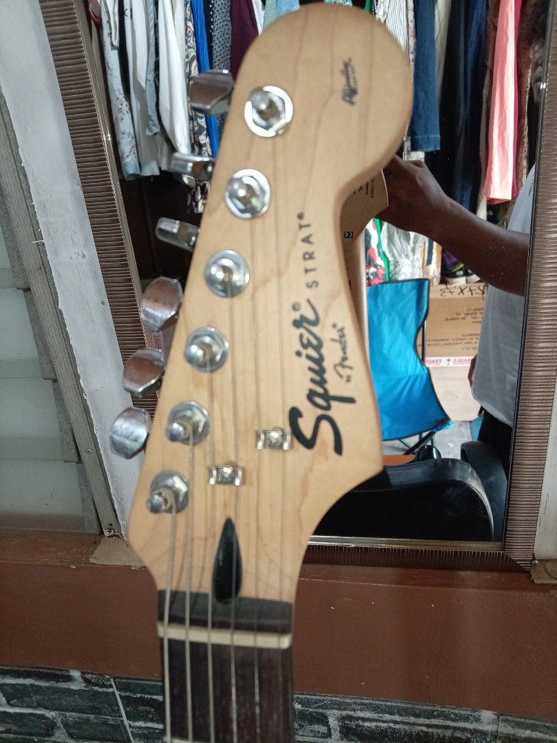Squier Stratocaster Electric Guitar (Category: Musical Instruments) located in Agdangan. Submitted by hairulmusicalcolection (Listing ID 1397835678, Image 3). Description: - Black Squier Stratocaster electric guitar - White pickguard - Three single-coil pickups - Tremolo bridge - Squier and Fender logos on headstock - Black body with white electronics cover - Maple neck.