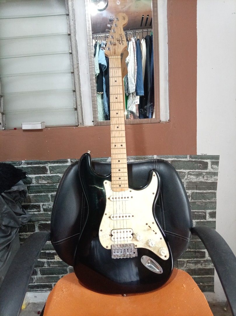 Squier Stratocaster Electric Guitar (Category: Musical Instruments) located in Agdangan. Submitted by hairulmusicalcolection (Listing ID 1397844267, Image 1). Description: - Squier Stratocaster electric guitar - Black body with white pickguard - Maple neck - Six strings - Three pickups - Tremolo bridge - Squier logo on headstock.