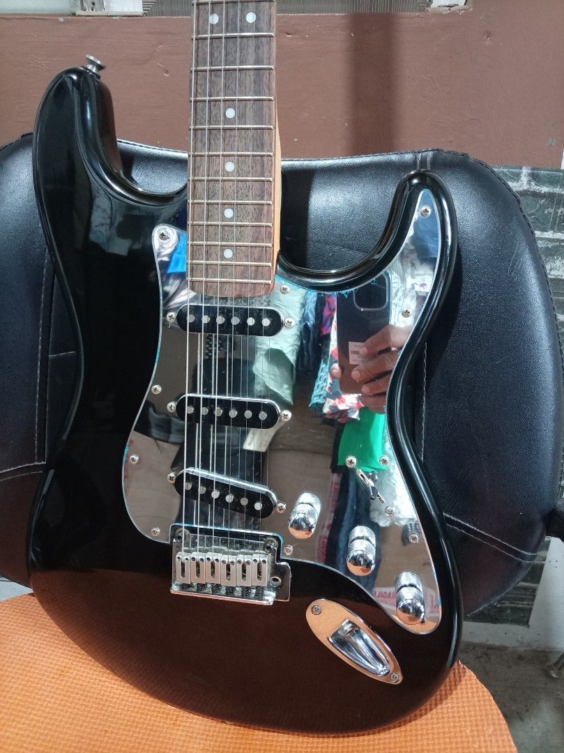 Squier Stratocaster Electric Guitar Standard (Category: Musical Instruments) located in Agdangan. Submitted by hairulmusicalcolection (Listing ID 1397853809, Image 2). Description: - Black Squier Stratocaster electric guitar - Black body with chrome pickguard - Three pickups - Maple neck and fretboard - Squier Stratocaster headstock logo.