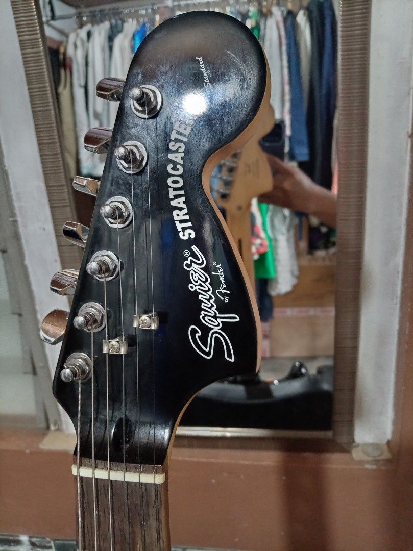 Squier Stratocaster Electric Guitar Standard (Category: Musical Instruments) located in Agdangan. Submitted by hairulmusicalcolection (Listing ID 1397853809, Image 3). Description: - Black Squier Stratocaster electric guitar - Black body with chrome pickguard - Three pickups - Maple neck and fretboard - Squier Stratocaster headstock logo.