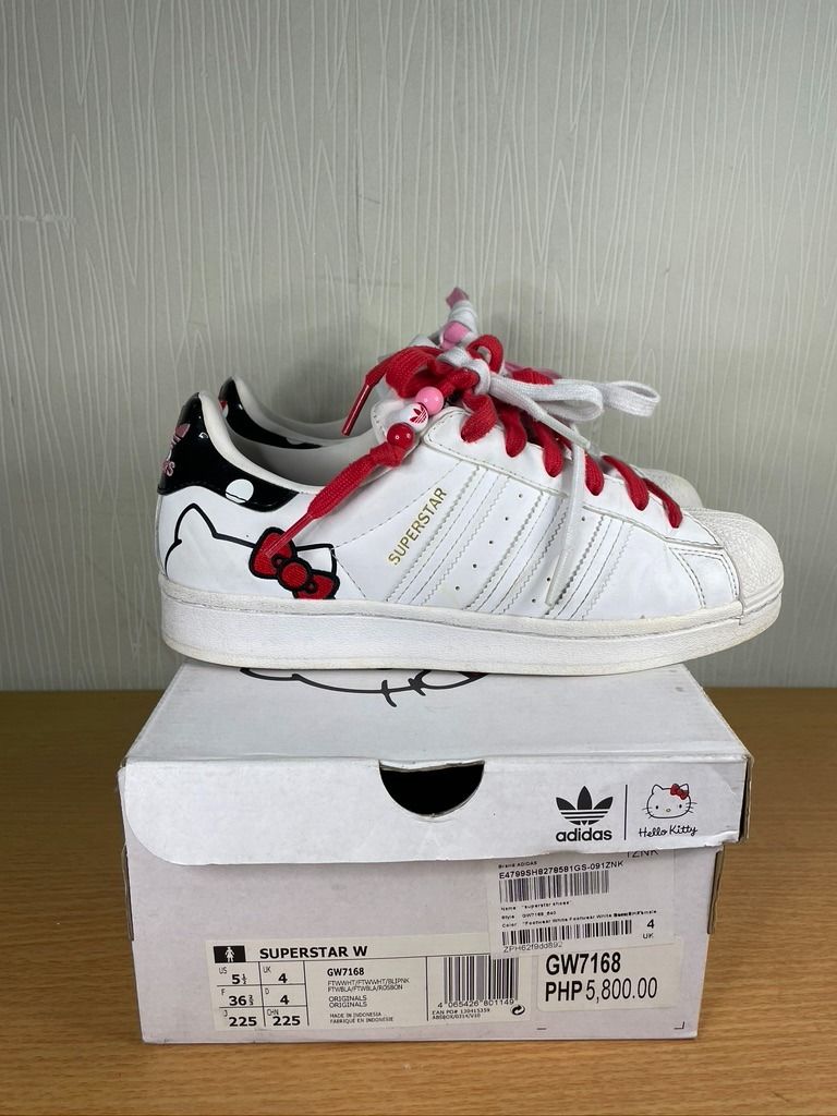 Adidas x Hello Kitty Superstar W Sneakers (Category: Sneakers) located in San Juan City. Submitted by declutterdiariesmnl (Listing ID 1398059489, Image 2). Description: - Adidas x Hello Kitty Superstar W Sneakers - Size US 5.5 / UK 4 - White leather upper - Features Kitty graphics and red bow details - Comes with pink and red laces - Includes original box Item is located in METRO MANILA. Grab / Lalamove booking is PREFERRED, and pickup/delivery a