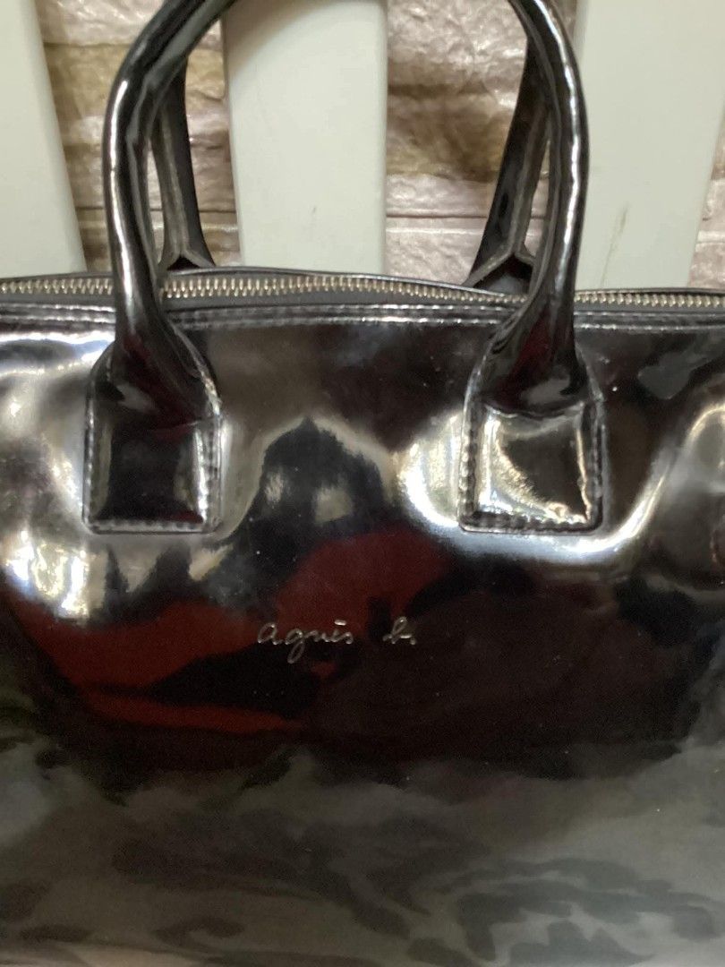 Agnes B. Black Patent Leather Handbag (Category: Luxury Bags & Wallets) located in Santa Rosa. Submitted by ahroncatpad (Listing ID 1398080893, Image 2). Description: - Agnes B. black patent leather handbag - Made of shiny patent leather - Features a top zipper closure - Includes dual top handles - Interior has multiple compartments - Agnes B. logo visible on the front.