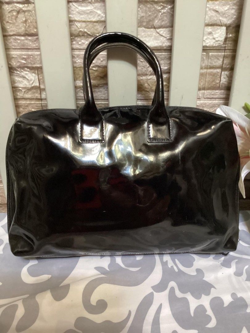 Agnes B. Black Patent Leather Handbag (Category: Luxury Bags & Wallets) located in Santa Rosa. Submitted by ahroncatpad (Listing ID 1398080893, Image 3). Description: - Agnes B. black patent leather handbag - Made of shiny patent leather - Features a top zipper closure - Includes dual top handles - Interior has multiple compartments - Agnes B. logo visible on the front.