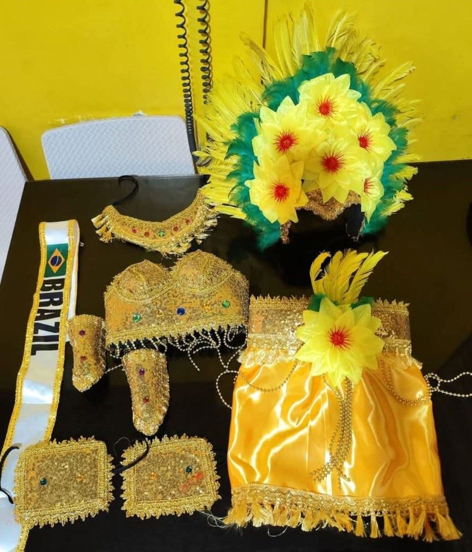 Brazilian Carnival Costume Set (Category: Babies & Kids Fashion) located in Cavite. Submitted by haileyetc. (Listing ID 1398130830, Image 2). Description: - Complete Brazilian carnival costume set - Includes: headdress, top, skirt, arm cuffs, ankle cuffs, and sash - Features a yellow and gold color scheme - Decorated with feathers and floral accents - Sash reads "BRAZIL" - Ideal for themed parties and performances.