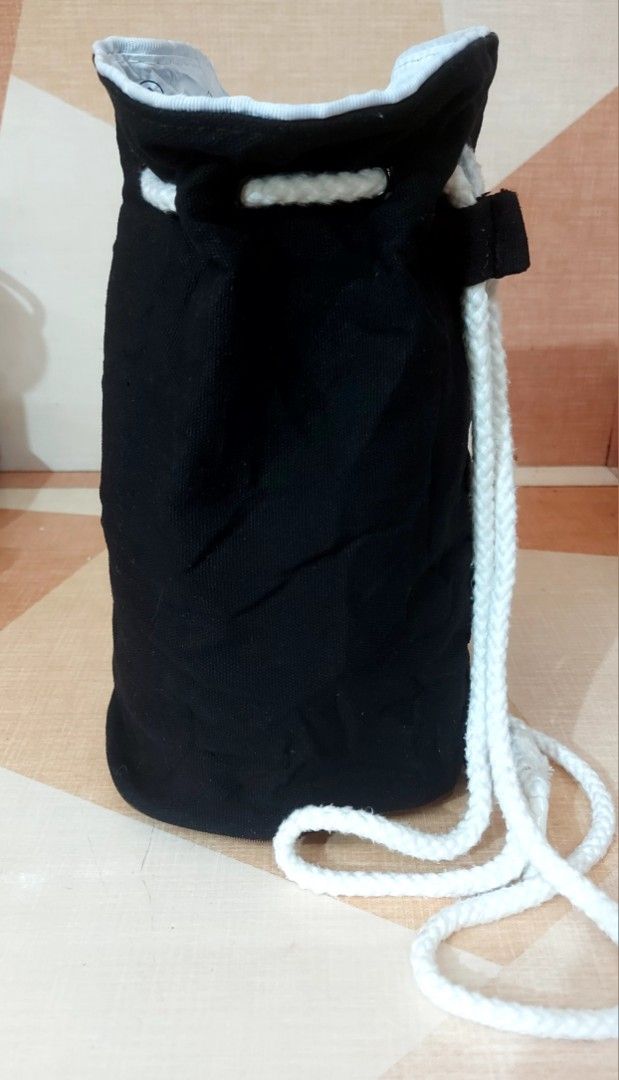 Chanel Drawstring Bag (Category: Luxury Bags & Wallets) located in Nabunturan. Submitted by creep012181 (Listing ID 1398021099, Image 3). Description: - Black drawstring bag - White "CHANEL" text - White drawstring closure - White rope strap - Cylindrical shape - Light grey interior lining - Ideal for small items.