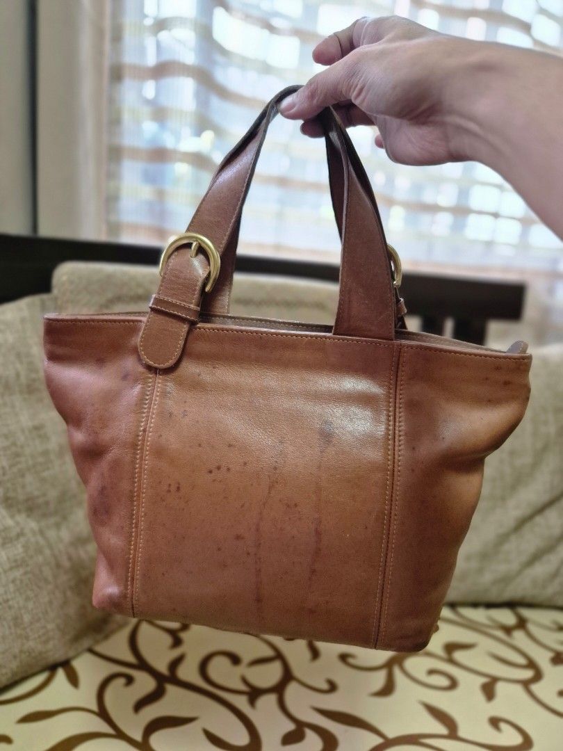Coach Leather Handbag (Category: Luxury Bags & Wallets) located in Quezon City. Submitted by jermiahh (Listing ID 1398028541, Image 2). Description: - Coach handbag - Warm brown color - Top handle design - Gold-tone buckle detail - Main compartment with zipper closure - Interior pocket - Includes Coach leather tag.