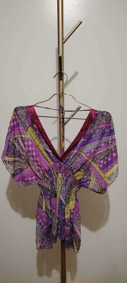 Hip Culture Printed Top (Category: Shirts) located in Pasay City. Submitted by dollph (Listing ID 1397999331, Image 2). Description: Can fit up to large - Vibrant print in purple, yellow, and pink - V-neck design with satin-like trim - Short sleeves - Gathered waist - Brand tag visible - Ideal for casual wear.
