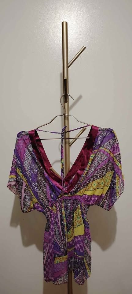 Hip Culture Printed Top (Category: Shirts) located in Pasay City. Submitted by dollph (Listing ID 1397999331, Image 1). Description: Can fit up to large - Vibrant print in purple, yellow, and pink - V-neck design with satin-like trim - Short sleeves - Gathered waist - Brand tag visible - Ideal for casual wear.