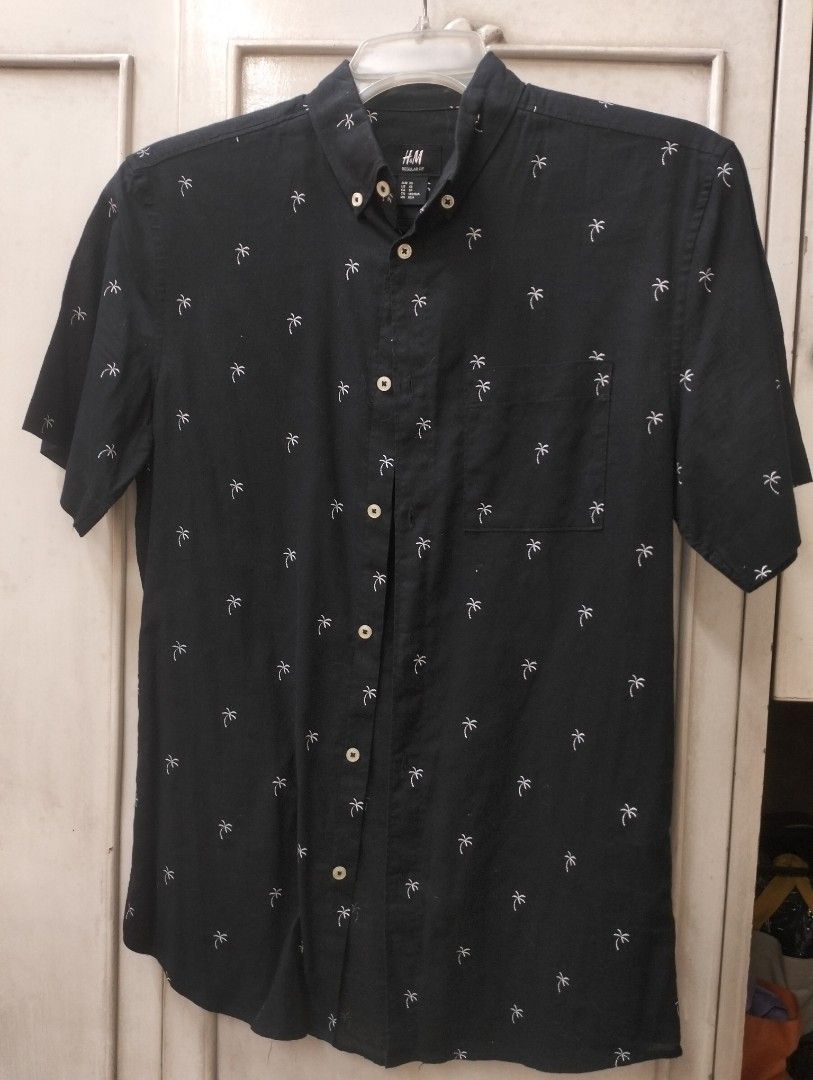 H&M Regular Fit Palm Tree Shirt - XS (Category: Tshirts & Polo Shirts ) located in Manila. Submitted by zyrakarll222 (Listing ID 1398058528, Image 1). Description: - H&M black short-sleeved shirt - Size: XS - Regular fit - Button-down design - Small palm tree pattern - Chest pocket - Button-down collar - Perfect for casual wear/ beach RFS: Unused; Tumaba na po kapatid ko Lalamove/ Grab/ J& T Express SF shouldered by buyer.