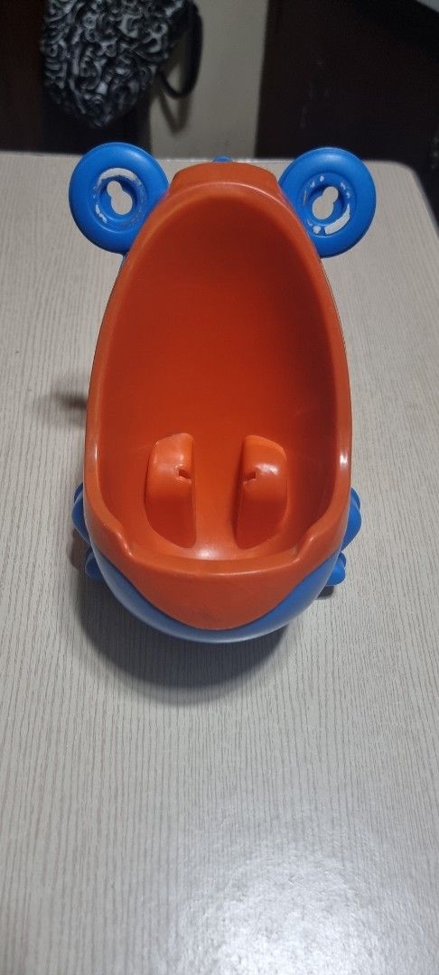Kids' Frog-Shaped Potty Training Urinal (Category: Toilet Training) located in Marikina City. Submitted by andreah_16 (Listing ID 1398003850, Image 2). Description: - Frog-shaped design - Blue and orange colors - Wide opening for easy use - Includes a splash guard - Made of durable plastic - Easy to clean - Helps with toilet training.