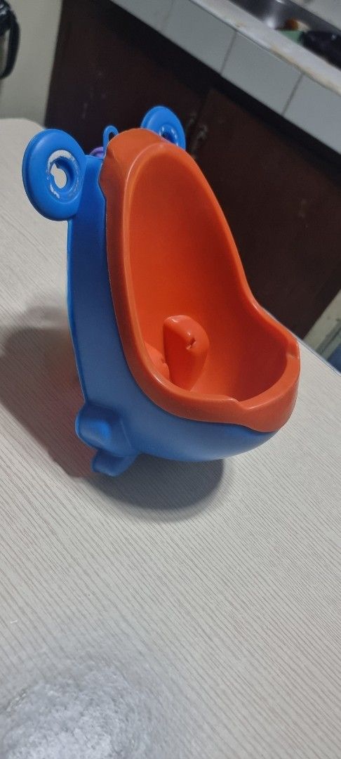Kids' Frog-Shaped Potty Training Urinal (Category: Toilet Training) located in Marikina City. Submitted by andreah_16 (Listing ID 1398003850, Image 3). Description: - Frog-shaped design - Blue and orange colors - Wide opening for easy use - Includes a splash guard - Made of durable plastic - Easy to clean - Helps with toilet training.