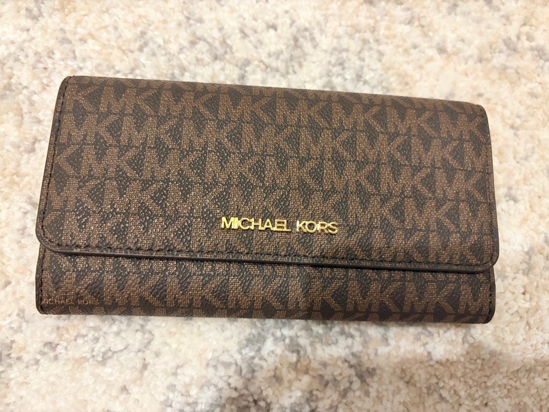 Michael Kors LG Trifold Brown Wallet (Category: Wallets & Card holders) located in Makati City. Submitted by decluttering_28 (Listing ID 1398113397, Image 1). Description: - Authentic Michael Kors LG Trifold wallet -bought in los angeles - Color: Brown - Features: - Multiple card slots - Clear ID window - Zippered compartment - Exterior: Signature MK logo pattern - Closure: Snap - Hardware: Gold-tone metal logo - Includes original receipt - Purch