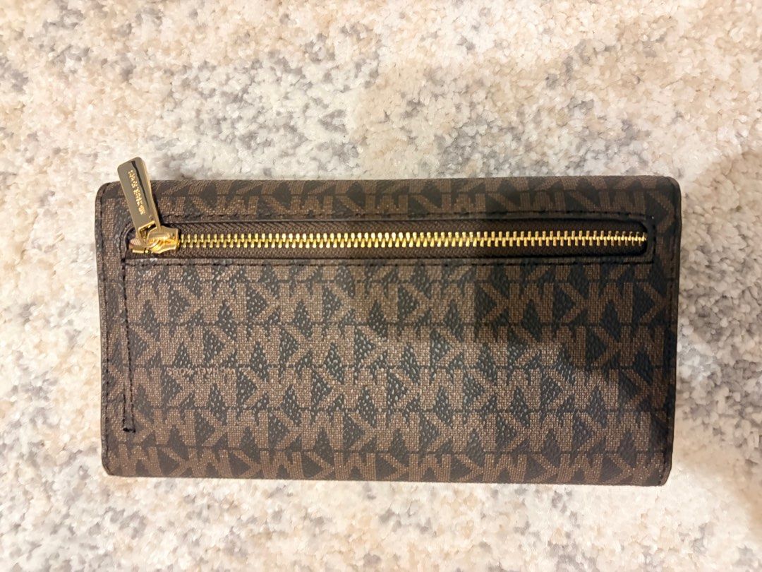 Michael Kors LG Trifold Brown Wallet (Category: Wallets & Card holders) located in Makati City. Submitted by decluttering_28 (Listing ID 1398113397, Image 2). Description: - Authentic Michael Kors LG Trifold wallet -bought in los angeles - Color: Brown - Features: - Multiple card slots - Clear ID window - Zippered compartment - Exterior: Signature MK logo pattern - Closure: Snap - Hardware: Gold-tone metal logo - Includes original receipt - Purch