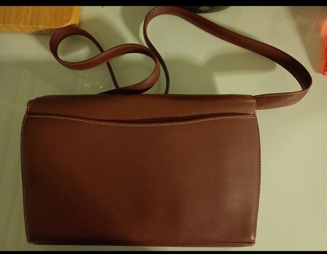 Must de Cartier Shoulder Bag (Category: Luxury Bags & Wallets) located in Quezon City. Submitted by mset.05011984 (Listing ID 1398116033, Image 3). Description: Elegant Must de Cartier shoulder bag in a rich brown color. Features a flap closure with a gold-tone clasp and a long shoulder strap. The interior includes a zippered pocket and the Must de Cartier logo. The bag has a classic design with visible stitching details..