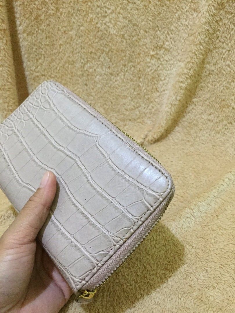 Beige Long Wallet (Category: Wallets & Card holders) located in Bulacan. Submitted by assorted.items (Listing ID 1398281695, Image 3). Description: - Beige crocodile-embossed exterior - Zip-around closure - Multiple card slots - Interior pocket - Includes wrist strap - Gold-toned zipper - Interior: Lighter beige.