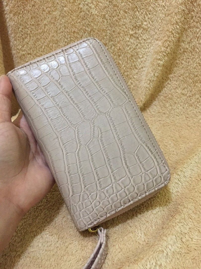 Beige Long Wallet (Category: Wallets & Card holders) located in Bulacan. Submitted by assorted.items (Listing ID 1398281695, Image 2). Description: - Beige crocodile-embossed exterior - Zip-around closure - Multiple card slots - Interior pocket - Includes wrist strap - Gold-toned zipper - Interior: Lighter beige.