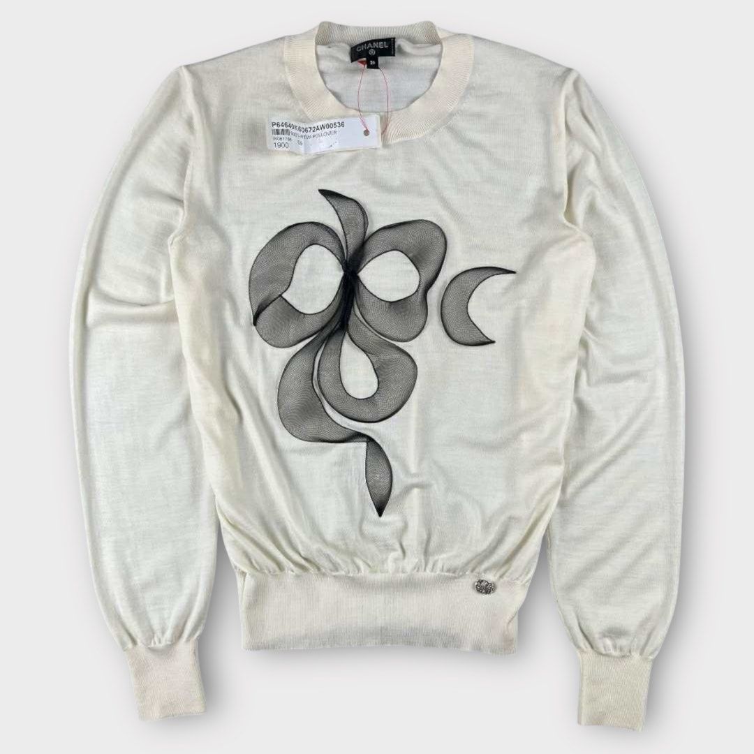 Chanel - Camelia Blooming Knit Wool Jumper Top (Category: Longsleeves) located in Los Banos. Submitted by declutterking (Listing ID 1398337366, Image 1). Description: Size 36 on tag Made of knitted wool. It has a silver hardware at the hem. Material: 100% virgin wool Dimensions: 13" shoulders 17.5" chest 21.75" length 23.5" sleeves 10.25" hem Brand new with tag Authentic .