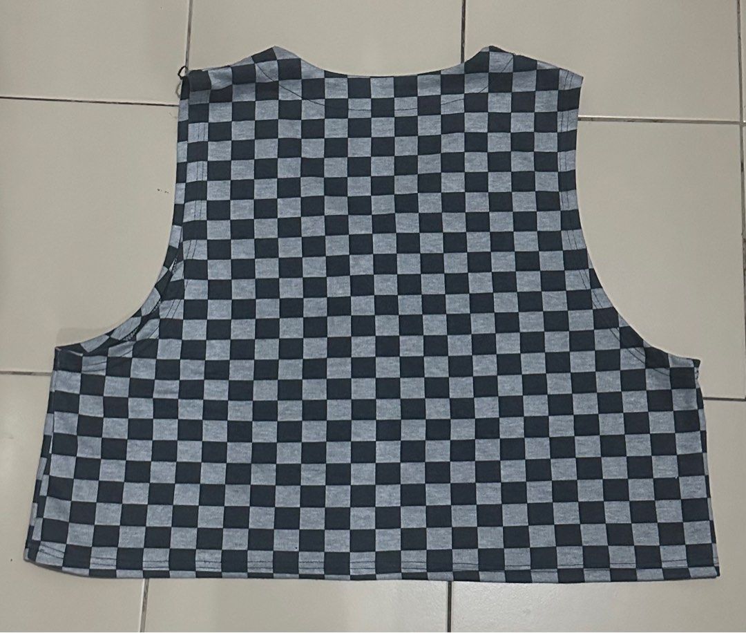 Grey and Black Checkered V-neck Crop Top (Category: Sleeveless) located in Manila. Submitted by janwhale (Listing ID 1398309259, Image 2). Description: Dimensions: 22"L x 26"W (Bust Area End-to-End) - Checkered crop top in gray and black - Features a V-neck design - Sleeveless cut - Cropped length - Made from lightweight cotton fabric - Perfect for casual wear.