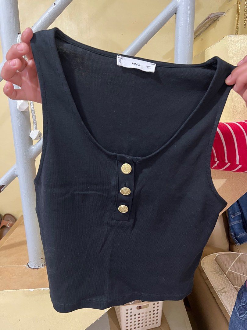 Mango Black Tank Top with Gold Buttons (Category: Sleeveless) located in Cordova. Submitted by choochookins (Listing ID 1398242190, Image 2). Description: - MNG black tank top - Size: EUR S, USA S, MEX CH - Scoop neck - Three gold buttons - Sleeveless - Ribbed fabric - Simple, classic design - Versatile for various outfits MOP: GCash/ Bank Transfer MOD: LBC/ JnT.
