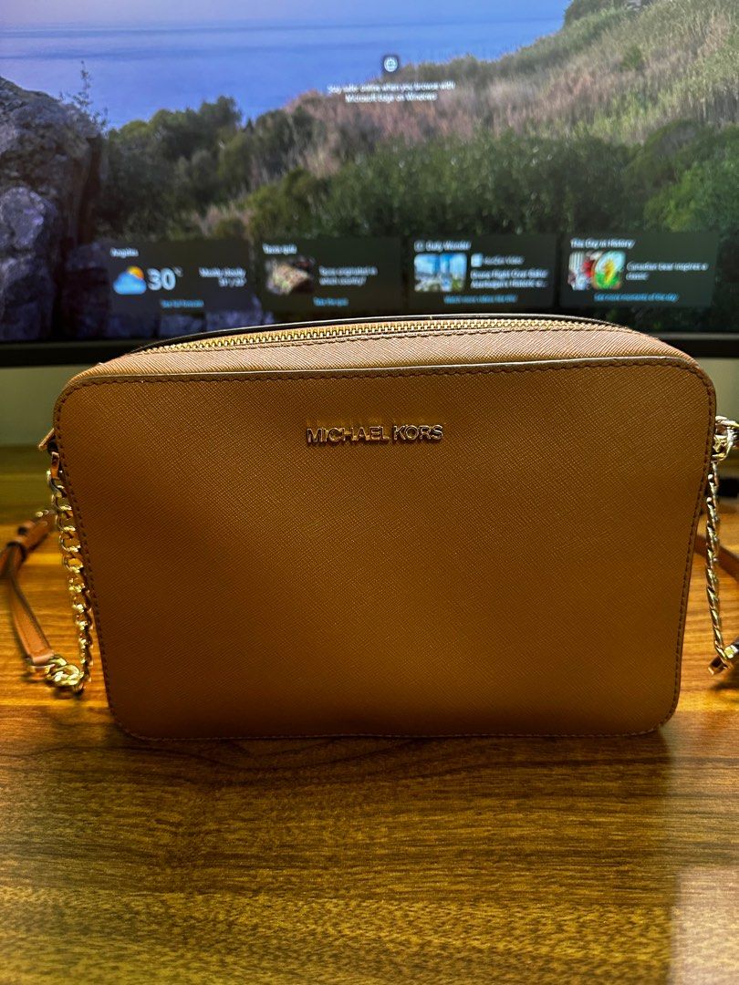 Michael Kors Jet Set Crossbody Bag (Category: Luxury Bags & Wallets) located in Angeles City. Submitted by exate (Listing ID 1398255865, Image 1). Description: - Michael Kors Jet Set Crossbody Bag - Color: Brown - Material: Leather - Strap: Gold-tone chain - Closure: Zip - Interior: Multiple compartments - Design: MK logo on front - Condition: Authentic.