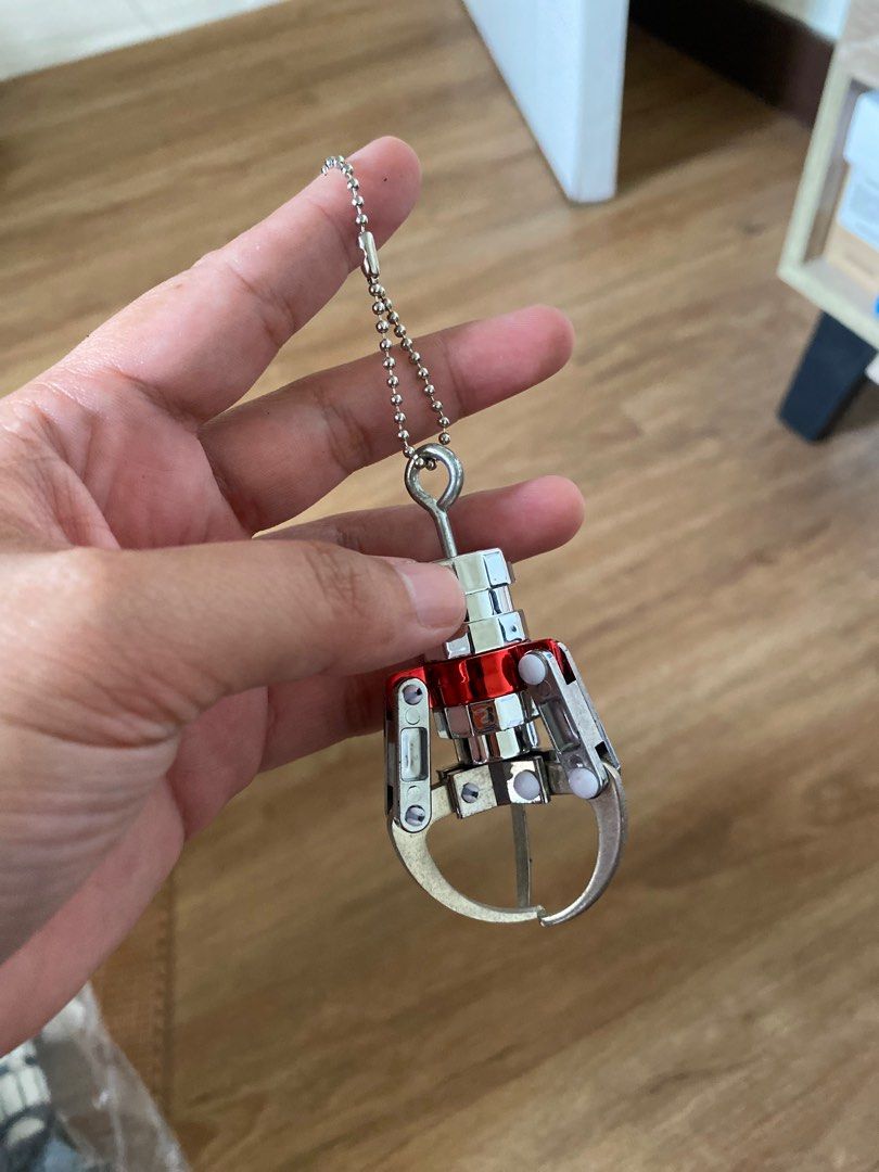 Mini Claw Machine Keychain (Category: Character Goods) located in Manila. Submitted by k0pimonster (Listing ID 1398248525, Image 1). Description: - Mini claw machine keychain - Features a silver and red claw - Fully functional claw mechanism - Includes a chain for easy attachment - Fun and unique accessory for keys or bags Loc: Pasig City.