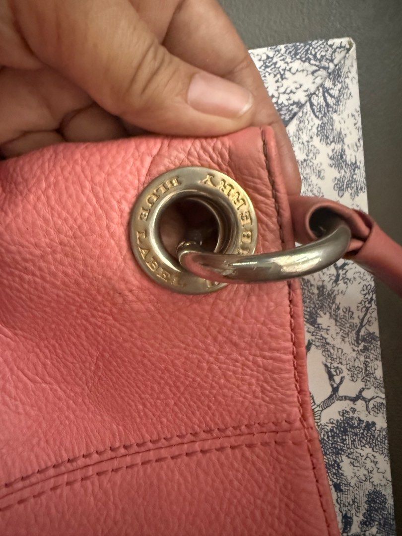 Burberry Blue Label Pink Handbag (Category: Luxury Bags & Wallets) located in Mercedes. Submitted by ddshoping238309 (Listing ID 1398377015, Image 3). Description: - Authentic Burberry Blue Label handbag - Color: salmon pink - Features: - Top handle - Shoulder strap - Plaid lining - Zippered pocket (interior) - Small zipper pocket (exterior) 2 sides - Gold-tone hardware - Snap closure - Brand name visible on the front..