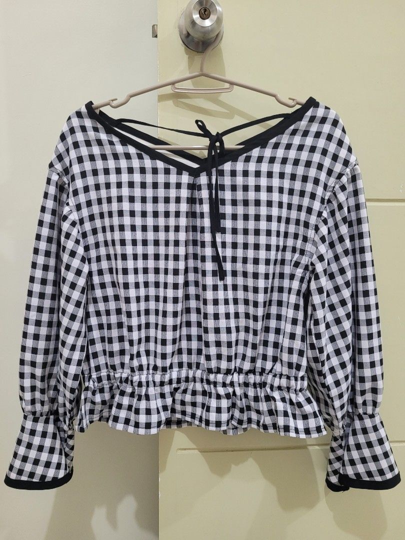 Checkered Blouse (Category: Blouses) located in Los Banos. Submitted by momo_mono (Listing ID 1398471560, Image 1). Description: - MAJESTIC LEGON blouse - Size: M - Classic black and white gingham pattern - Long sleeves with flared cuffs - Gathered waist - V-neckline with tie detail rfs: declutter.