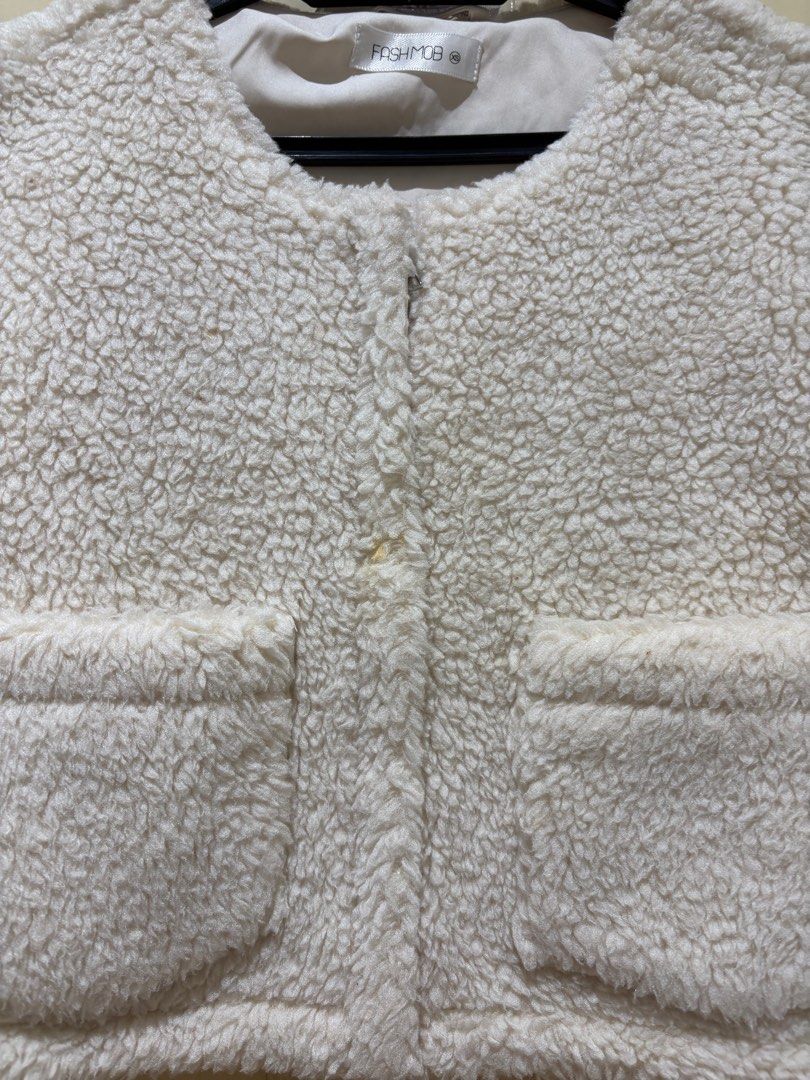 Jacket (Category: Coats, Jackets and Outerwear) located in Puchong. Submitted by silverturtle_376ccc (Listing ID 1398478364, Image 2). Description: - FASHMOB cream-colored cropped jacket - Size: xs - Features: - Round neckline - Two front pockets - Button closures - Long sleeves with buttoned cuffs - Material: Soft, teddy bear-like fabric.