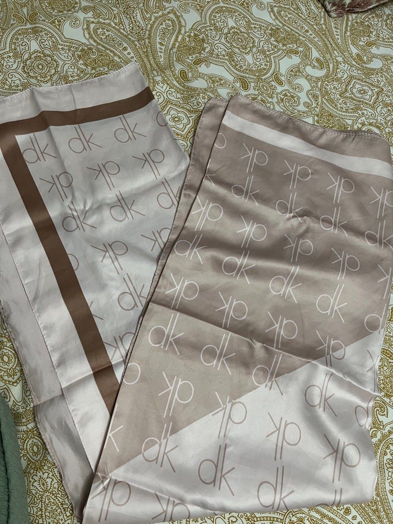 DK Patterned Scarf (Category: Hijabs) located in Kuala Lumpur. Submitted by bungaaprillll (Listing ID 1398458072, Image 3). Description: - Pink scarf with a 'dk' pattern - Brown border and accents - Made of a smooth, silky material - Rectangular shape - Can be styled in multiple ways.