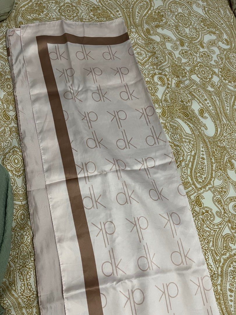 DK Patterned Scarf (Category: Hijabs) located in Kuala Lumpur. Submitted by bungaaprillll (Listing ID 1398458072, Image 2). Description: - Pink scarf with a 'dk' pattern - Brown border and accents - Made of a smooth, silky material - Rectangular shape - Can be styled in multiple ways.