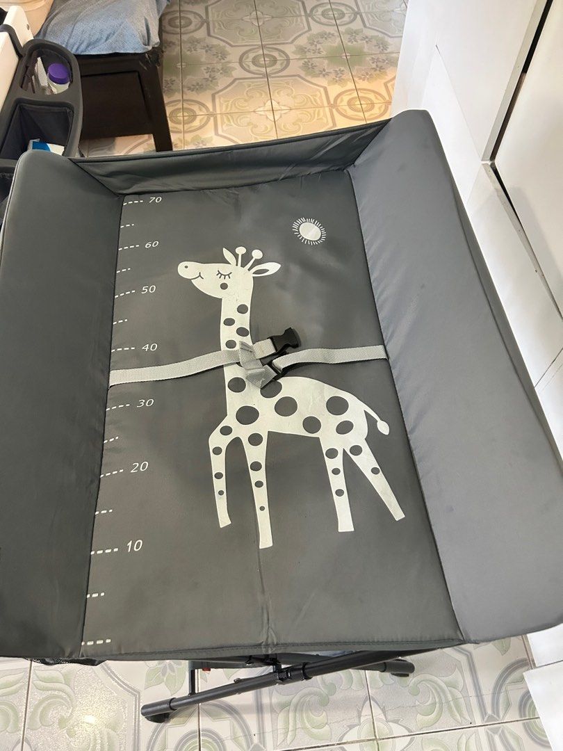 Foldable Baby Changing Table with Giraffe Design (Category: Changing Mats & Accessories) located in San Pedro. Submitted by ukaynikukay (Listing ID 1398412789, Image 1). Description: - Built-in measuring guide - Includes safety strap - Storage basket for essentials - Lower shelf for extra storage - Sturdy, foldable frame - Wheels for easy movement and locks - Collapsible for easy storage - Up to 15kg capacity.
