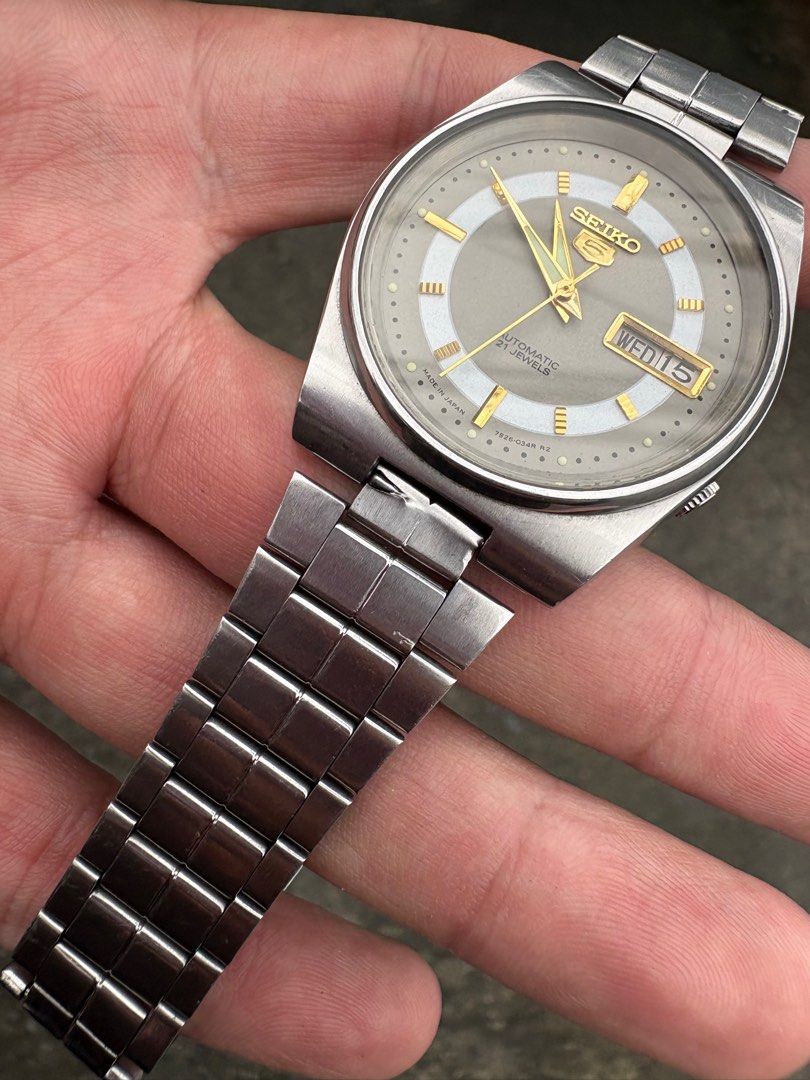 Seiko 5 (Category: Luxury Watches) located in Manila. Submitted by sophiaalex70506 (Listing ID 1398367619, Image 2). Description: - Vintage Seiko 5 automatic watch - Grey dial with gold-colored markers and hands - Displays day and date - Stainless steel bracelet included - Seiko logo and model information on case back - In working condition.