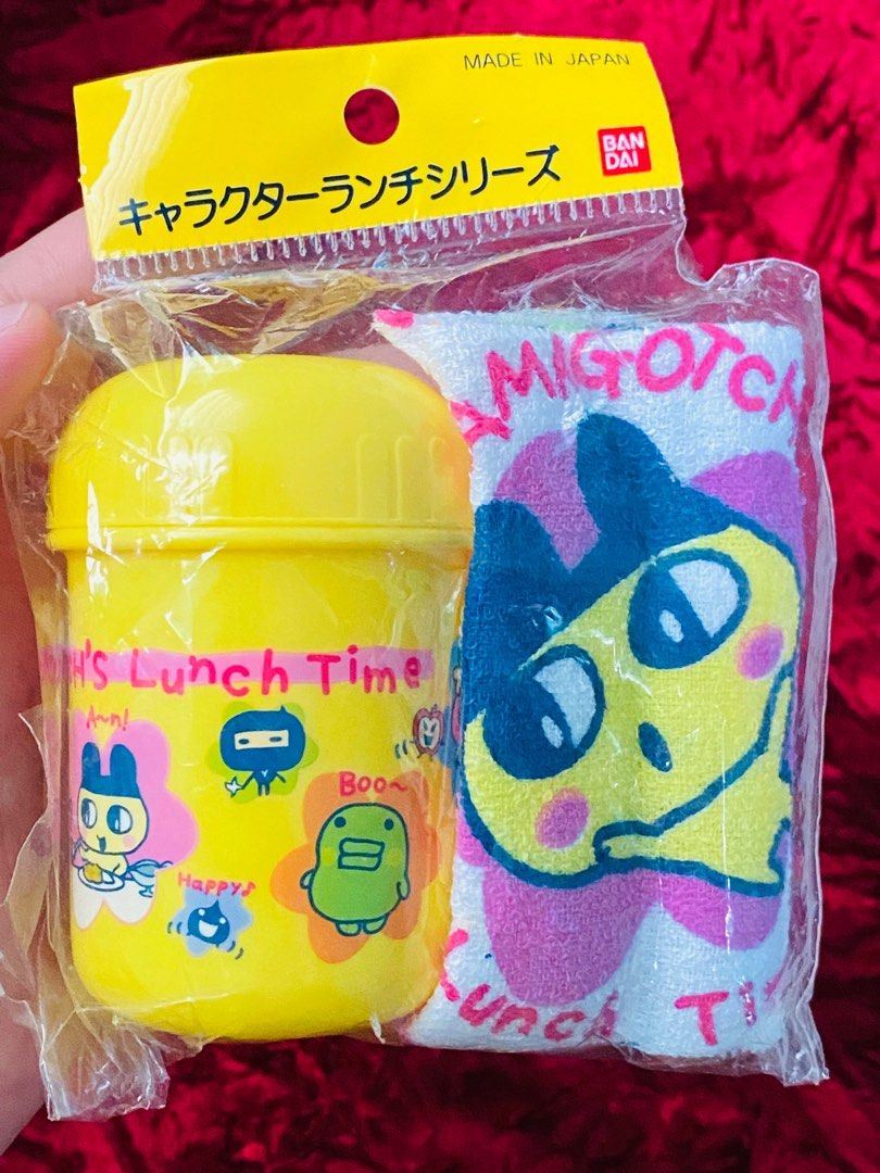 Tamagotchi Face towel with container set 280 (Category: Food Organization & Storage) located in Zamboanga. Submitted by kawaii_omocha_est2020 (Listing ID 1398402364, Image 1). Description: - Authentic Tamagotchiface towel witj container set (Made in Japan). - Includes a yellow container and matching towel. - Lunch box features Tamagotchi characters and "Lunch Time" text. - Towel features a large Tamagotchi character and "Tamagotchi's Lunch Time" 