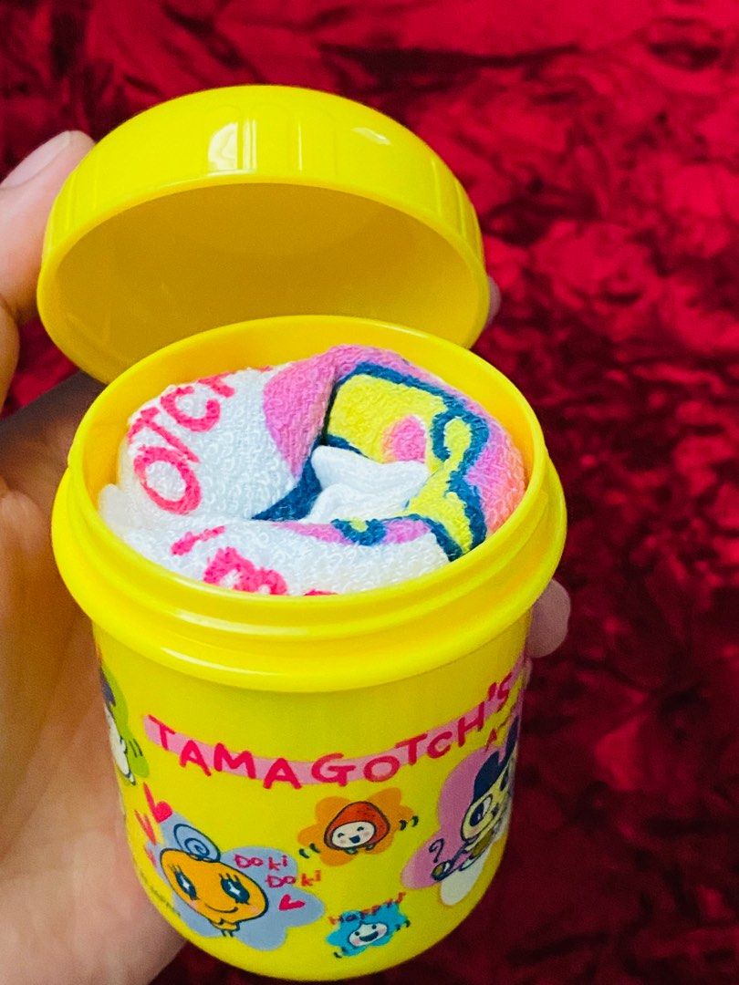 Tamagotchi Face towel with container set 280 (Category: Food Organization & Storage) located in Zamboanga. Submitted by kawaii_omocha_est2020 (Listing ID 1398402364, Image 3). Description: - Authentic Tamagotchiface towel witj container set (Made in Japan). - Includes a yellow container and matching towel. - Lunch box features Tamagotchi characters and "Lunch Time" text. - Towel features a large Tamagotchi character and "Tamagotchi's Lunch Time" 