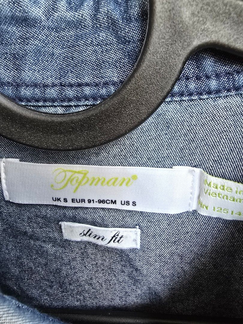 Topman Denim Slim Fit Shirt (Category: Tshirts & Polo Shirts ) located in Cebu City. Submitted by henry_007 (Listing ID 1398377089, Image 2). Description: Topman denim shirt in size S. Features a slim fit design. Made in Vietnam. The shirt is made of 65% cotton and 35% polyester. It has a button-down closure and long sleeves. The shirt is a solid blue color. .