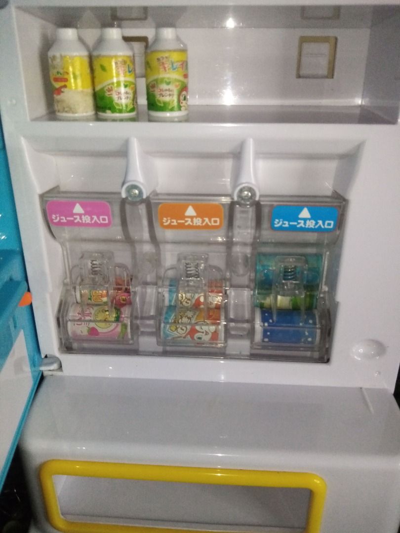 Anpanman Toy Vending Machine (Category: Designer & Blind Box Toys) located in Tanza. Submitted by leonskidskorner (Listing ID 1398579869, Image 1). Description: - Anpanman-themed toy vending machine - Includes juice dispensers - Comes with miniature drink cans - Features a blue and white design with Anpanman characters - Has a small refrigerator compartment - Includes a coin slot and dispensing area - Perfect for imaginative play!.