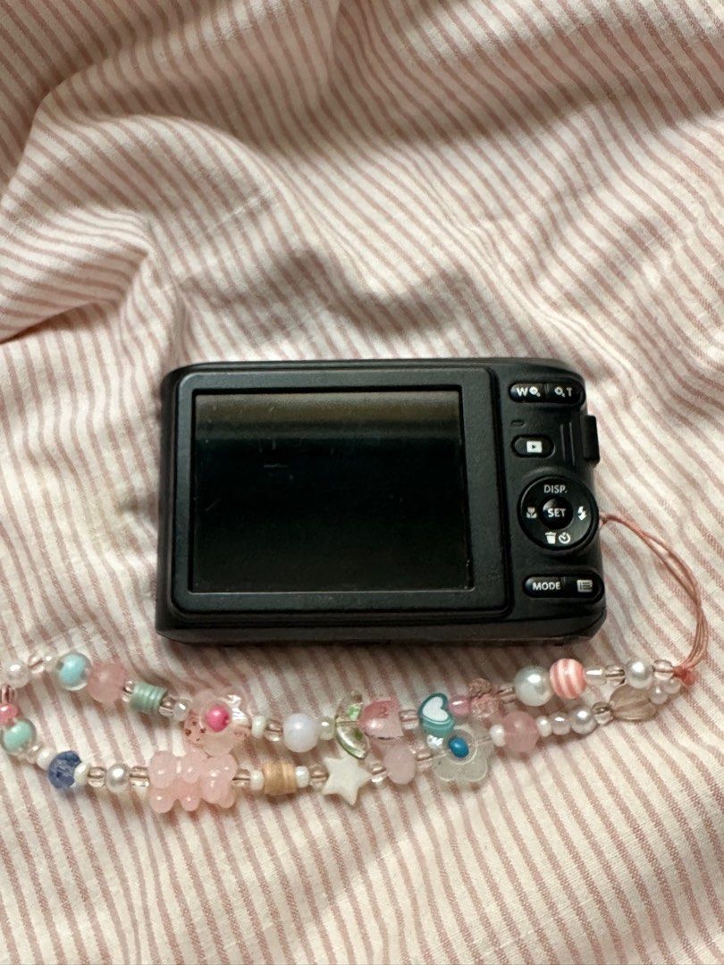 Kodak PIXPRO FZ45 Digital Camera (Category: Cameras) located in Mandaluyong City. Submitted by madb888 (Listing ID 1398529808, Image 2). Description: - Kodak PIXPRO FZ45 digital camera - Black body with stickers - Features a zoom lens - Records full HD video - Includes a decorative wrist strap with beads and charms - Screen and buttons are visible issue : has a few scratches .