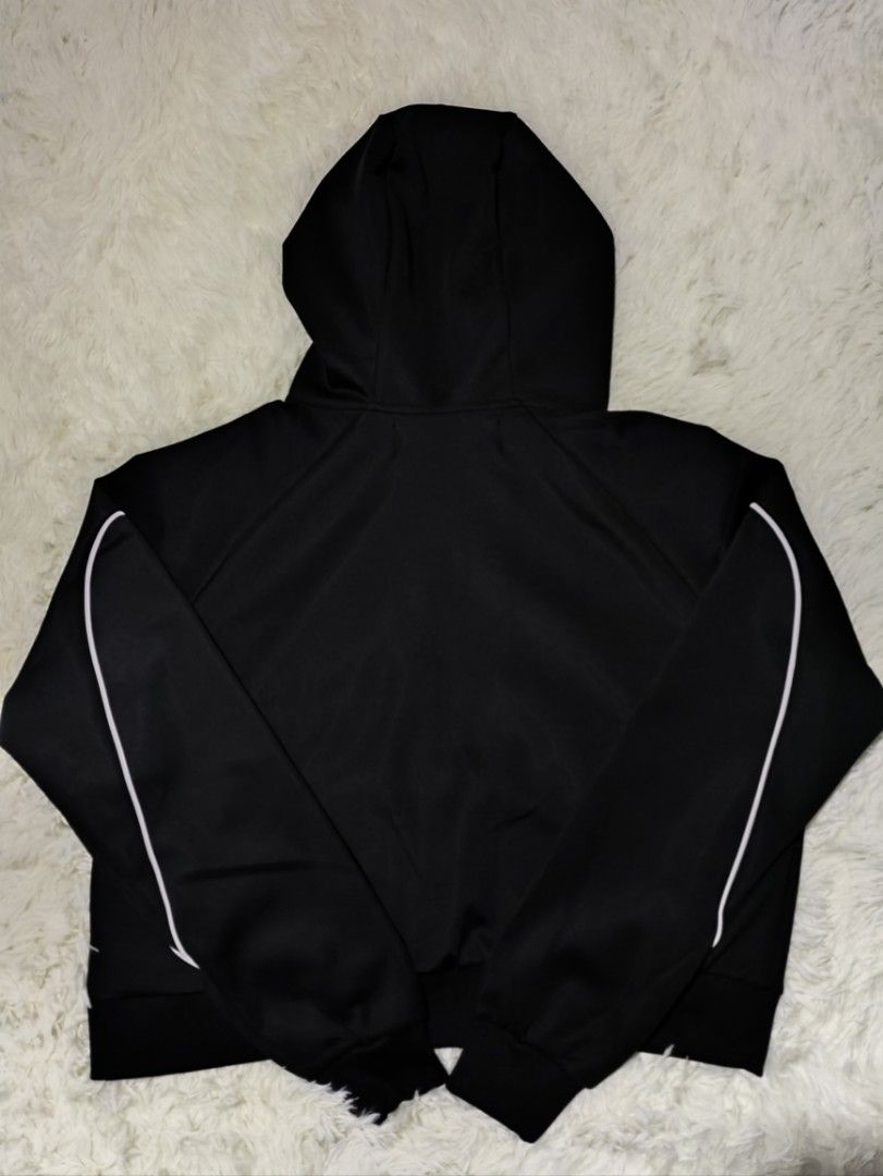 Mowalola Black Hoodie Jacket (Category: Coats, Jackets and Outerwear) located in Caloocan City. Submitted by 808akali (Listing ID 1398675976, Image 2). Description: Black hoodie jacket from Mowalola. Features a full zip closure, hood, and white accents along the sleeves. The Mowalola logo is prominently displayed on the front. The jacket is size S and made of a polyester and spandex blend. The jacket has a ribbed hem and cuffs..