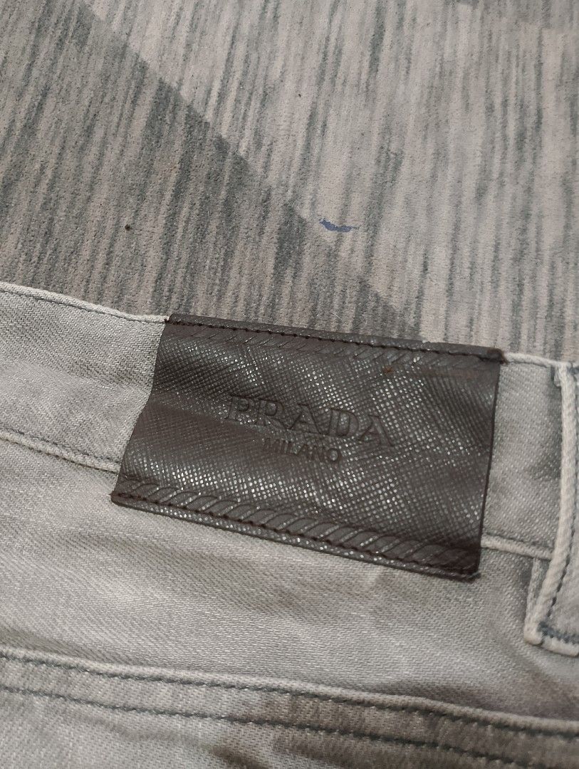 Prada Tight Fit Jeans (Category: Luxury Apparel) located in Santiago. Submitted by dc_daily_thrift (Listing ID 1398699432, Image 3). Description: - Prada Tight Fit jeans - Color: Grey - Size: 29 on tag 32 on measuring tape - Features: Button closure with Prada logo, classic five-pocket design, straight leg fit - Details: Prada logo on back leather patch and inside tag - Made in Romania.