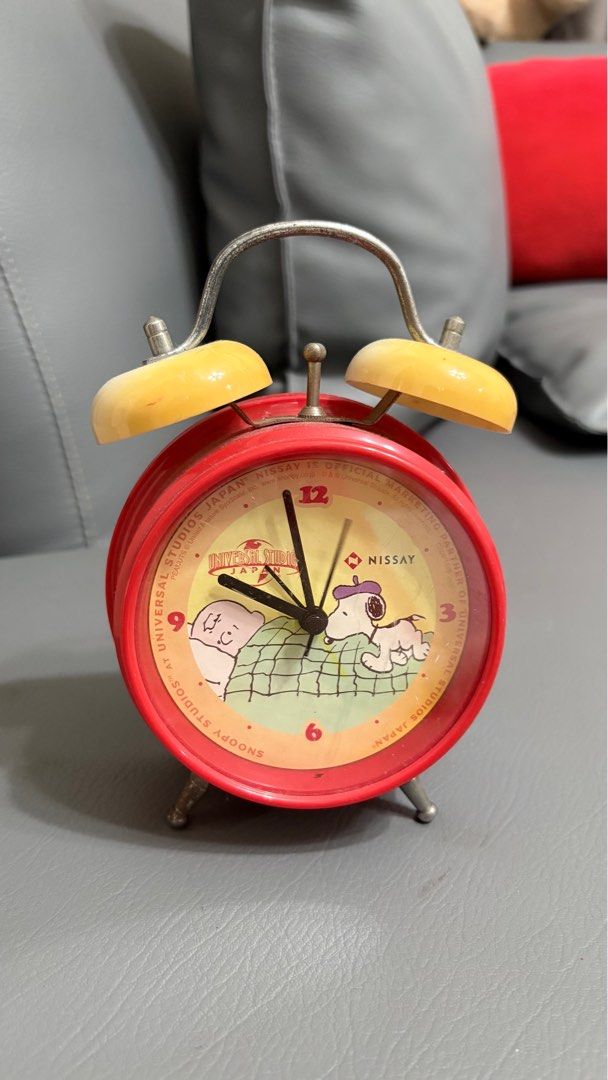 Working pero losyang na. Universal Studios Japan Snoopy Alarm Clock (Category: Clocks) located in Cabanatuan. Submitted by esnyupi (Listing ID 1398659259, Image 1). Description: - Vintage Snoopy alarm clock - From Universal Studios Japan - Features Snoopy and Woodstock - Red body with cream-colored bells - Silver handle - Round shape with small legs - Includes winding mechanism and switch.
