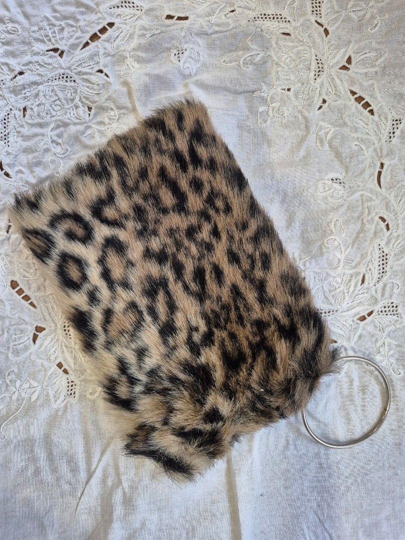 Leopard Print Clutch with Ring Handle (Category: Clutches) located in Quezon City. Submitted by soaring7 (Listing ID 1398786974, Image 2). Description: Faux fur. Clutch features a striking leopard print design. It has a ring handle for easy carrying. The interior is lined with black fabric and includes a zipper closure. The clutch is compact and stylish, perfect for carrying essentials. It's a unique accessory that adds a touch of flair to any ou