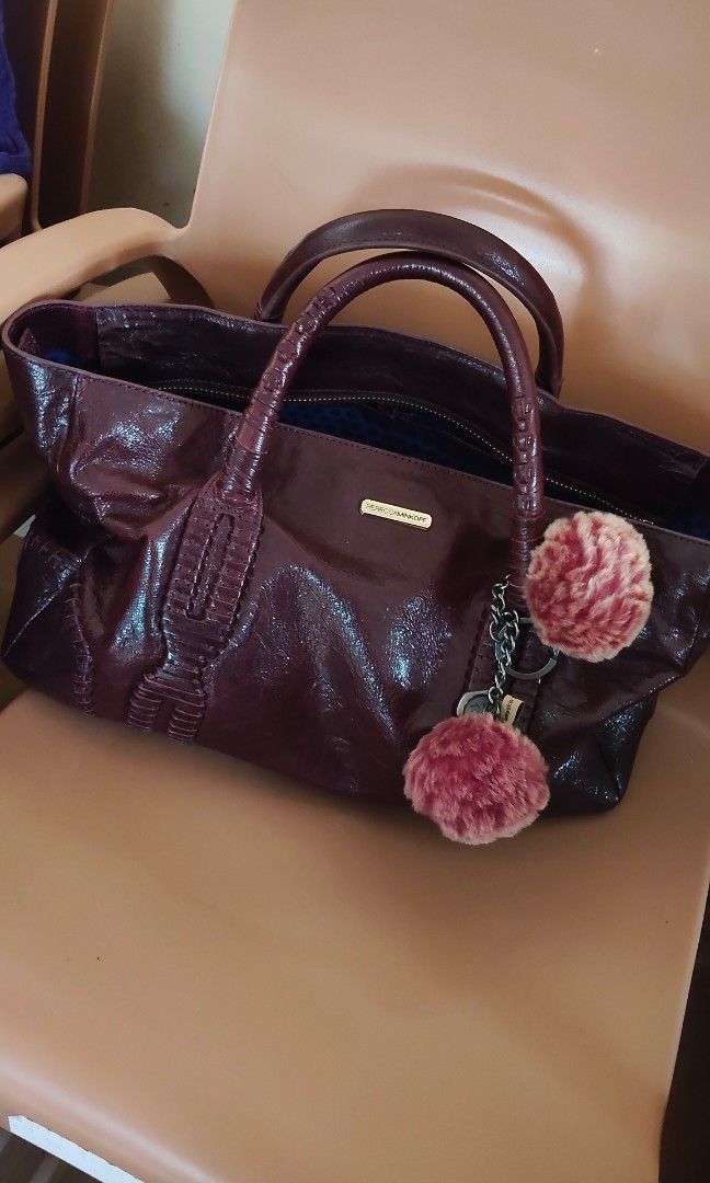Rebecca Minkoff Handbag with Shoulder Strap (Category: Luxury Bags & Wallets) located in Davao. Submitted by nononbenjielunaivyibop (Listing ID 1395067232, Image 3). Description: - Rebecca Minkoff handbag -Satchel or tote style - Dark exterior with a shiny finish - Double handles and detachable shoulder strap - with intricate detailing and unique hardware - Interior with blue polka dot lining - Zipper closure - Includes a small charm.