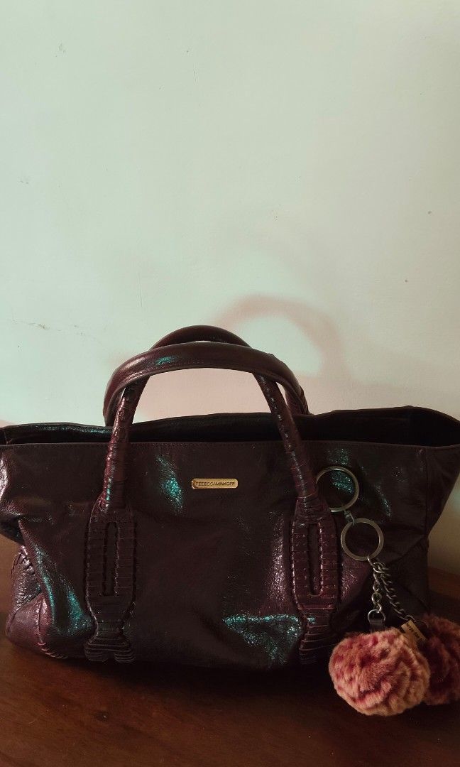 Rebecca Minkoff Handbag with Shoulder Strap (Category: Luxury Bags & Wallets) located in Davao. Submitted by nononbenjielunaivyibop (Listing ID 1395067232, Image 2). Description: - Rebecca Minkoff handbag -Satchel or tote style - Dark exterior with a shiny finish - Double handles and detachable shoulder strap - with intricate detailing and unique hardware - Interior with blue polka dot lining - Zipper closure - Includes a small charm.