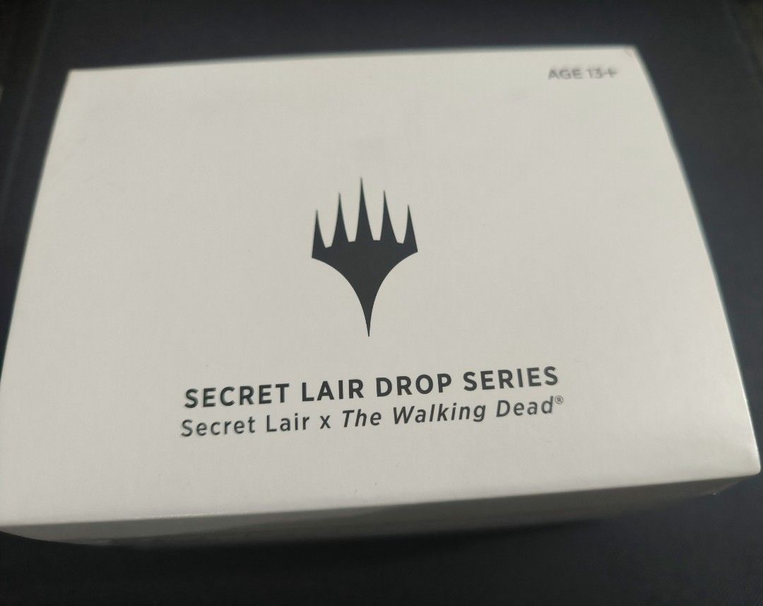 Secret Lair x The Walking Dead (Category: Storybooks) located in Makati City. Submitted by embubbles (Listing ID 1398852516, Image 1). Description: bnew, sealed Magic the Gathering Secret Lair X Walking dead -the other side of the box has a lil damage from tape removal, otherwise everything is intact. No dents from the box. Loc: Makati meetup glorietta/gbelt/walter lalamove/J&T .