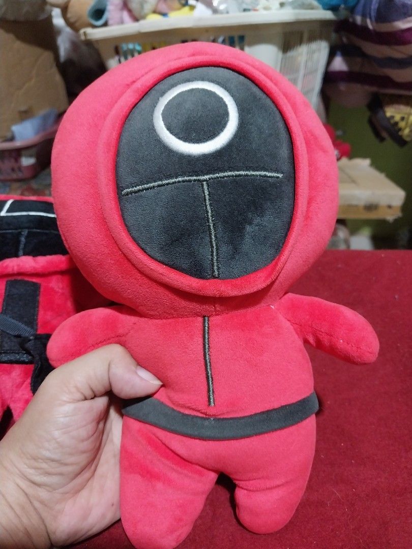 Squid Game Guard Plush Toy (Category: Plushies & Soft Toys) located in Abucay. Submitted by g_treasures (Listing ID 1398708228, Image 3). Description: - Squid Game guard plush toys! - Available in two designs: square mask and circle mask. - Features the iconic red jumpsuit and black mask. - Soft and huggable plushies. - Great for display or play. - A unique gift for fans!.