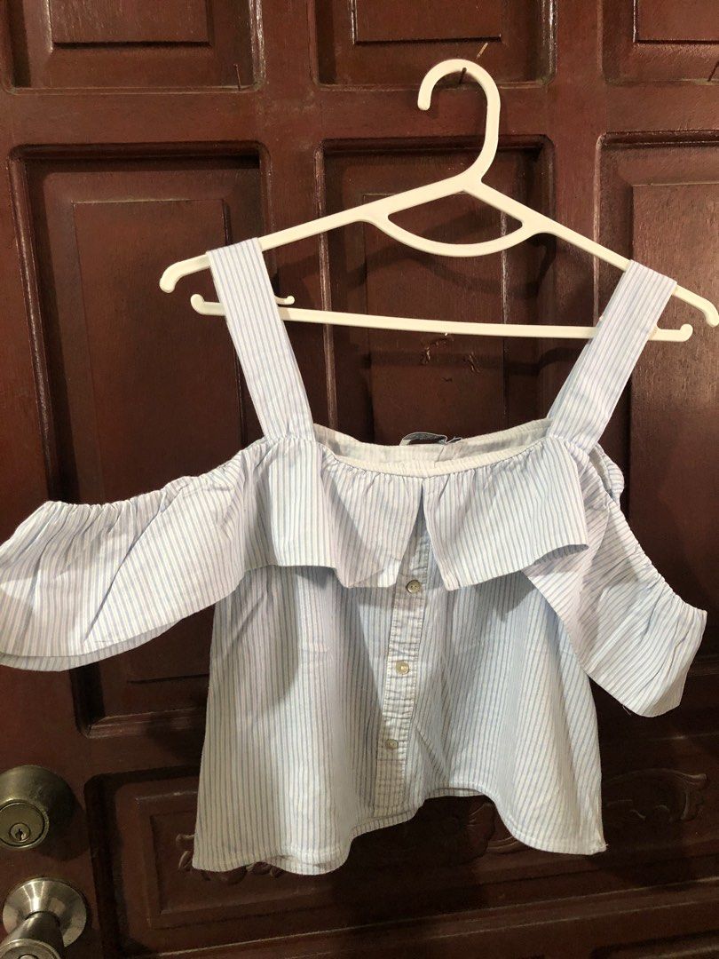 Zara Trafaluc Off-Shoulder Top (Category: Blouses) located in Bacoor. Submitted by declutteredbygem (Listing ID 1398704646, Image 2). Description: - Zara Trafaluc off-shoulder top - Striped pattern - Ruffled neckline - Button-down front - Color: Light blue and white - Size: S/36 (EUR/USA 26) - Made in Morocco.