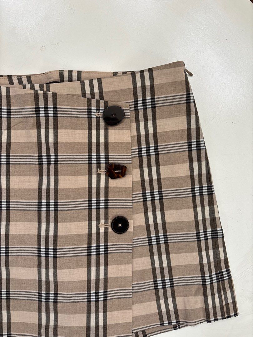 MNG Basics Plaid Skirt (Category: Skirts) located in Rodriguez. Submitted by alekshivers (Listing ID 1398881777, Image 2). Description: - MNG Basics plaid skirt - Classic plaid pattern - Neutral tones - Button closure and side zipper - Size: EUR 36, USA 4, MEX 3 - Made in Vietnam - Versatile for various outfits.