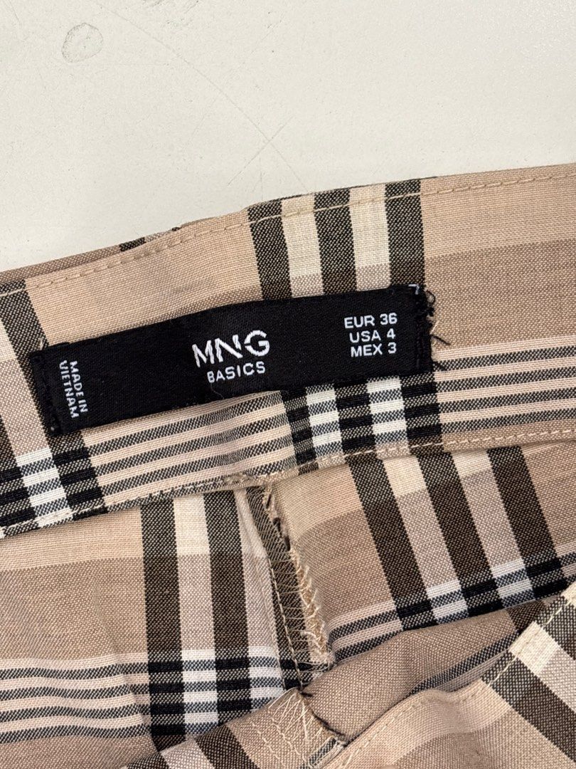 MNG Basics Plaid Skirt (Category: Skirts) located in Rodriguez. Submitted by alekshivers (Listing ID 1398881777, Image 3). Description: - MNG Basics plaid skirt - Classic plaid pattern - Neutral tones - Button closure and side zipper - Size: EUR 36, USA 4, MEX 3 - Made in Vietnam - Versatile for various outfits.